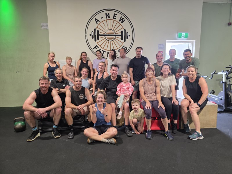 A-New Fitness community group photo in front of the logo